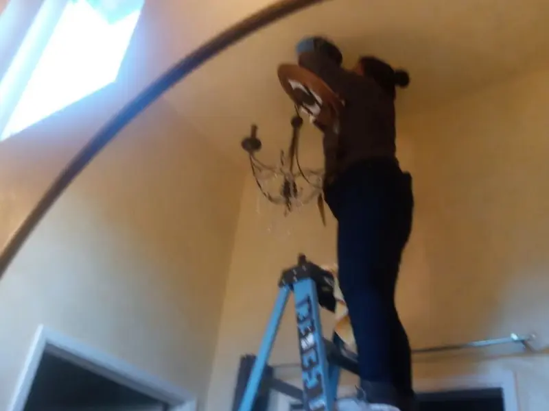 Electrician installing a chandelier in a Chili residence